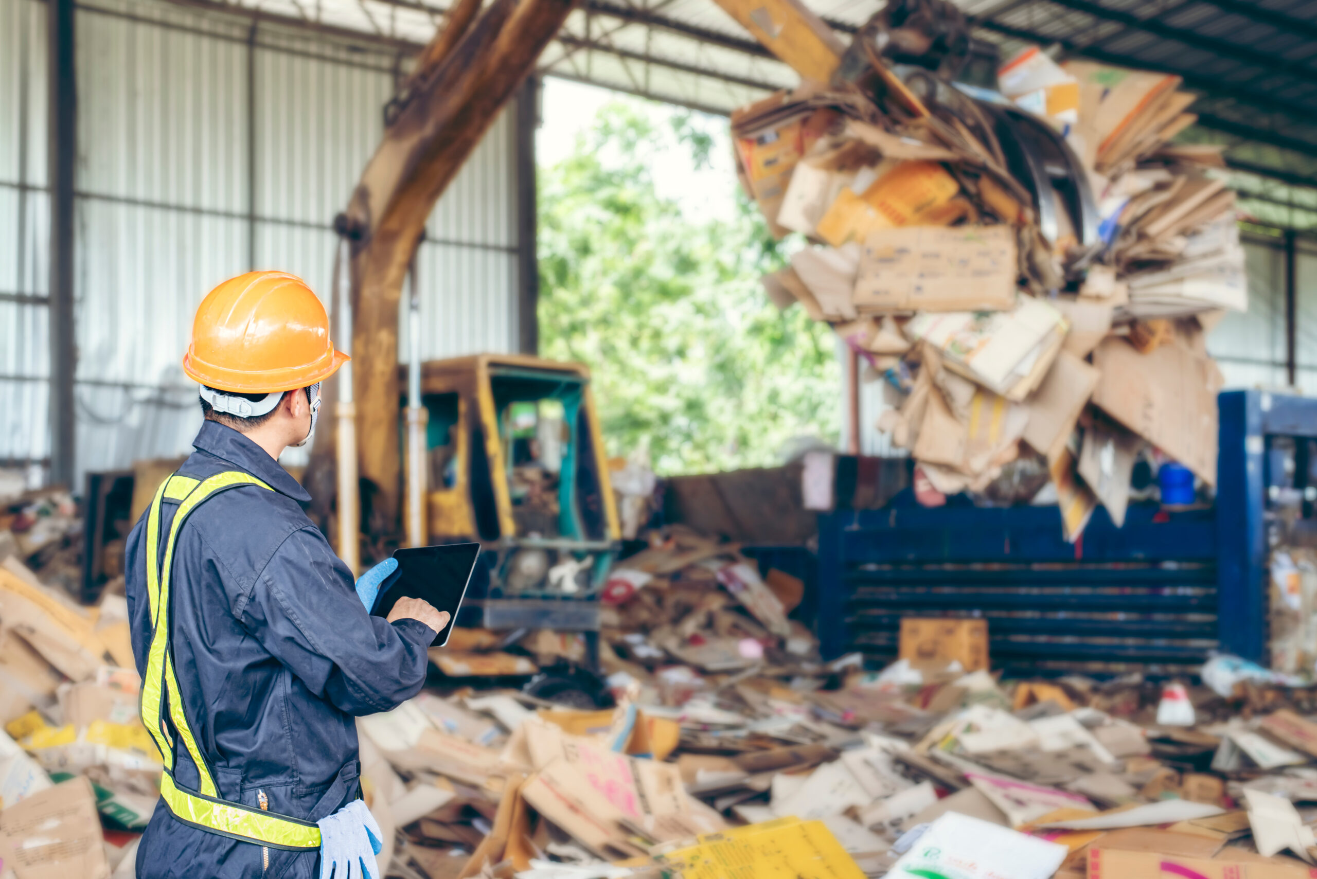 Travailleur dans une usine de recyclage contrôlant une machine